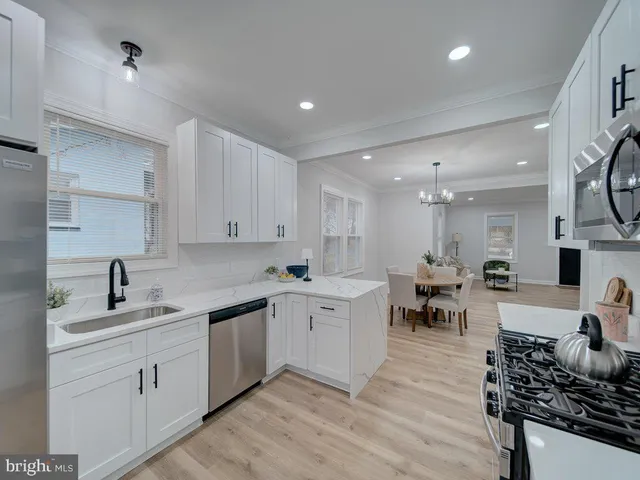 a kitchen with white cabinets and sink