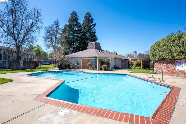 a front view of a house with swimming pool having outdoor seating
