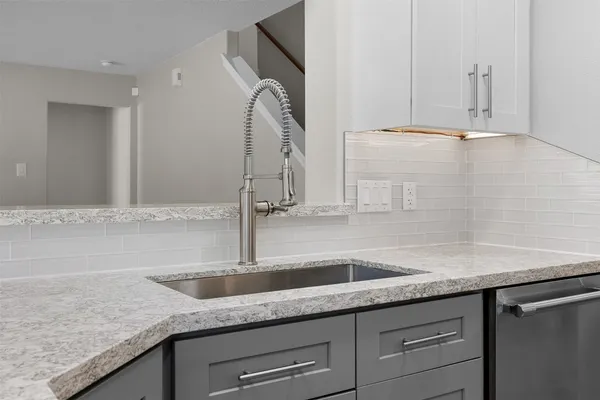 a kitchen with granite countertop white cabinets and a sink