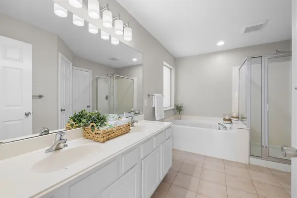 a spacious bathroom with a bathtub sink and mirror