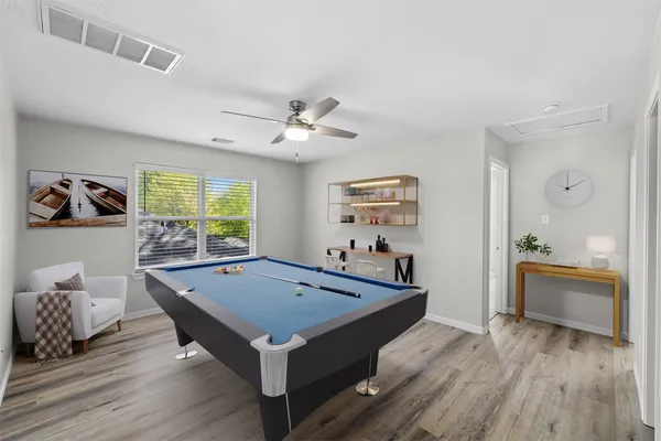 a room with pool table and windows