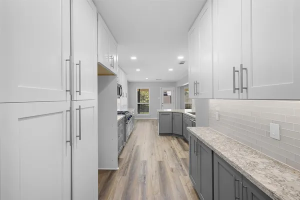 a view of a kitchen with a sink and dishwasher a refrigerator with wooden floor