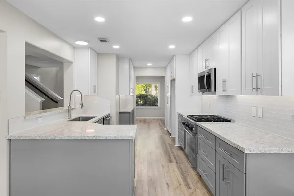 a kitchen with granite countertop a sink and a stove top oven
