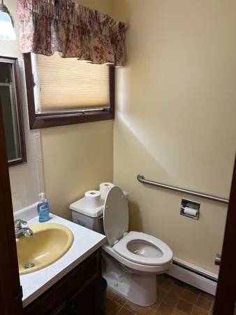 a bathroom with a toilet sink and mirror