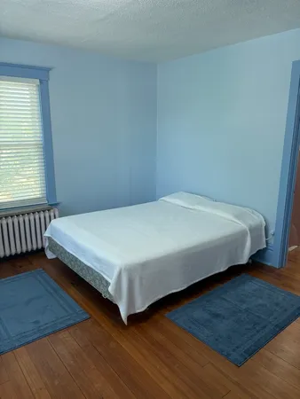 a large bed sitting in a bedroom next to a window