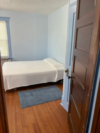 a bed sitting in a bedroom next to a window