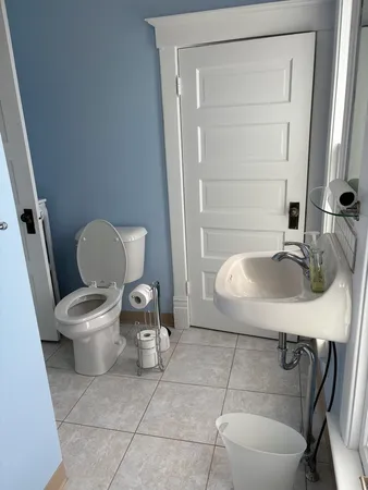 a bathroom with a sink a toilet and a mirror