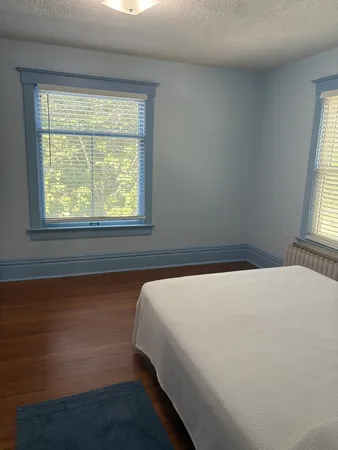 a bed sitting in a bedroom next to a window