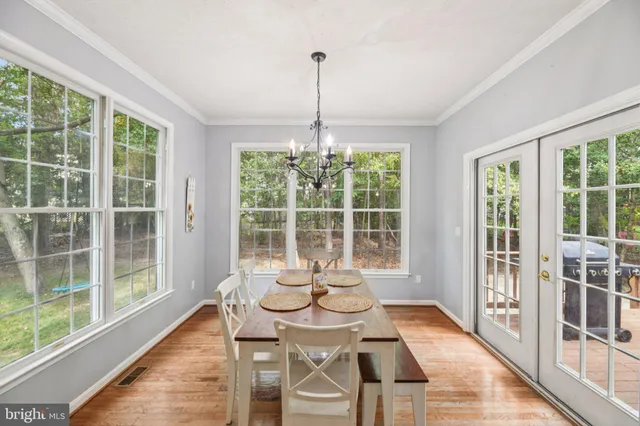a dining room with furniture window and wooden floor