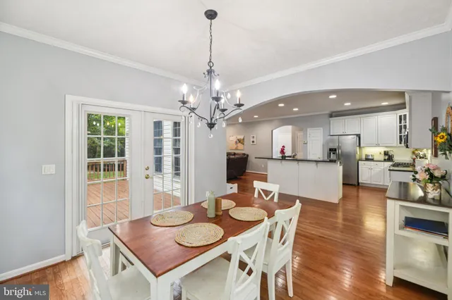 a view of a dining room and livingroom with furniture wooden floor a chandelier