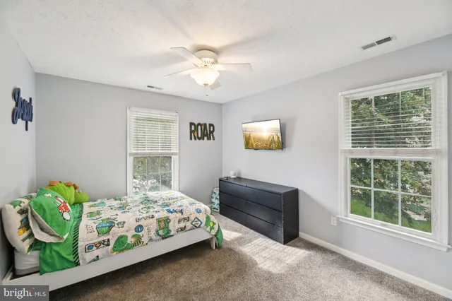 a bedroom with a bed mirror and window