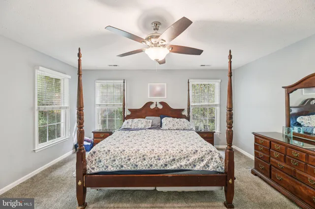 a bed sitting in a spacious bedroom next to a window