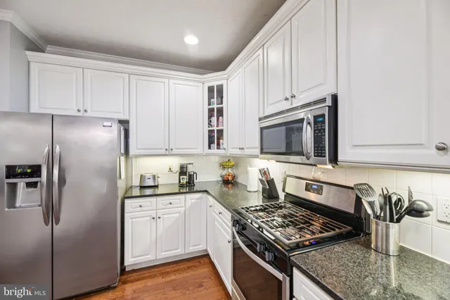 a kitchen with stainless steel appliances granite countertop a stove a sink dishwasher and a refrigerator