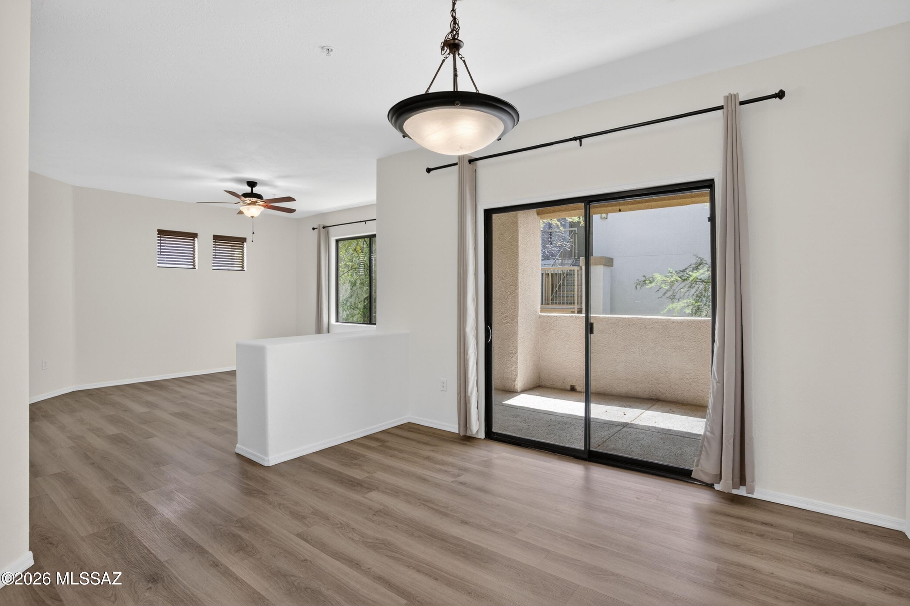 2550 East River Road, Unit 4204 Tucson, AZ 85718 - Photo 9 of 36 a view of an empty room with wooden floor and a window
