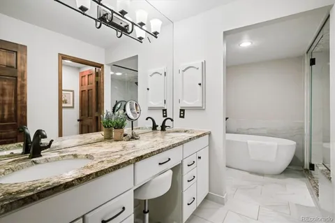 a bathroom with a granite countertop sink mirror and bathtub