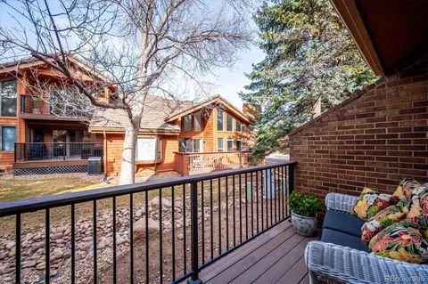 a view of a wooden chairs and a fire pit in the balcony