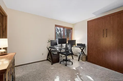 a view of a workspace with furniture and a window
