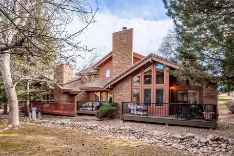 a view of a house with a large tree and wooden fence