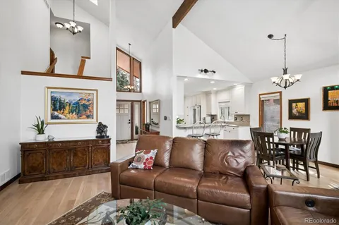 a living room with furniture a dining table and a chandelier