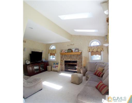 29 West Cliff Road Colonia, NJ 07067 - Photo 11 of 25 a living room with furniture a fireplace and a flat screen tv