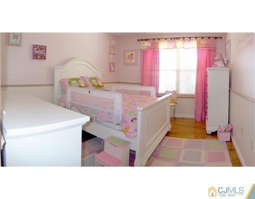 29 West Cliff Road Colonia, NJ 07067 - Photo 17 of 25 a room with a bed and a flat screen tv