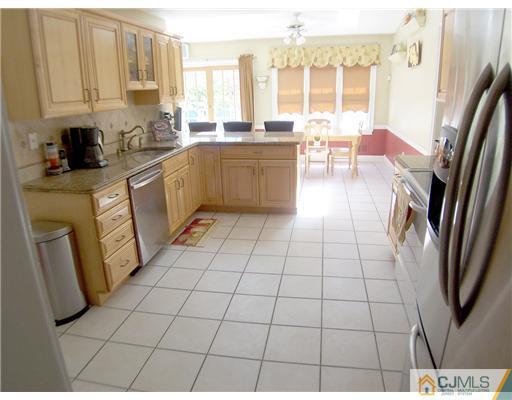 29 West Cliff Road Colonia, NJ 07067 - Photo 6 of 25 a kitchen with stainless steel appliances a sink a counter top space and a window
