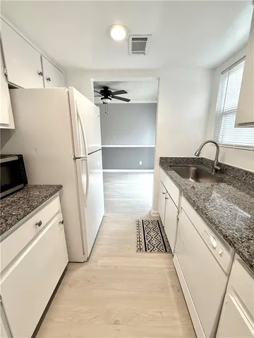 a kitchen with a sink a refrigerator and a stove top oven