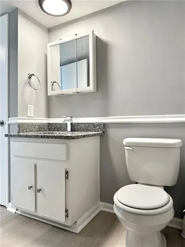 a bathroom with a granite countertop toilet sink and mirror