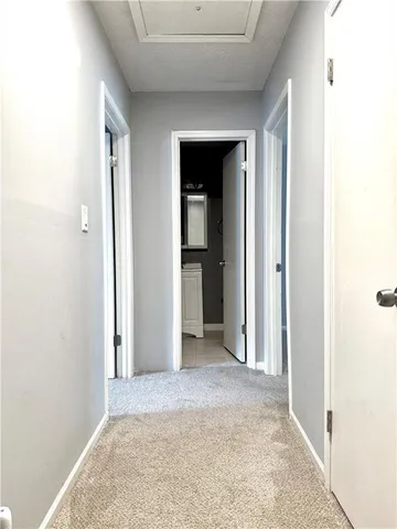 a view of a room with a hallway and wooden floor