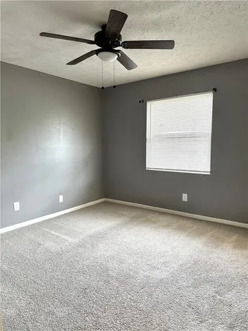 an empty room with a fan and a window