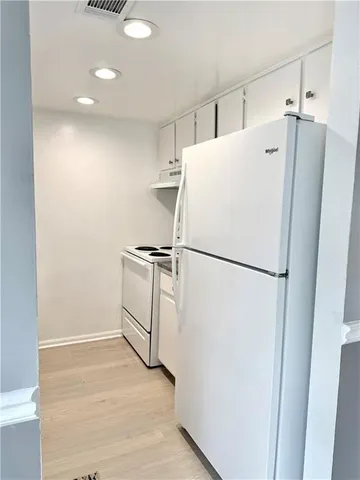 a white refrigerator freezer sitting in a kitchen