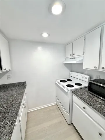a white stove top oven sitting inside of a kitchen