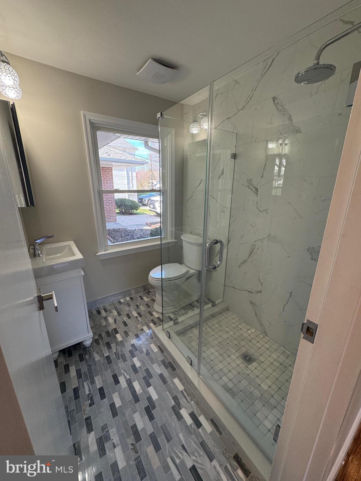 5612 Namakagan Road Bethesda, MD 20816 - Photo 11 of 34 a bathroom with a granite countertop sink a mirror and a shower