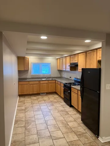 a kitchen with stainless steel appliances granite countertop a refrigerator and a sink