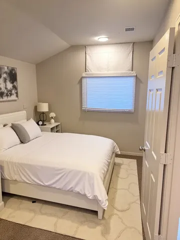a bedroom with a bed and painting on the wall