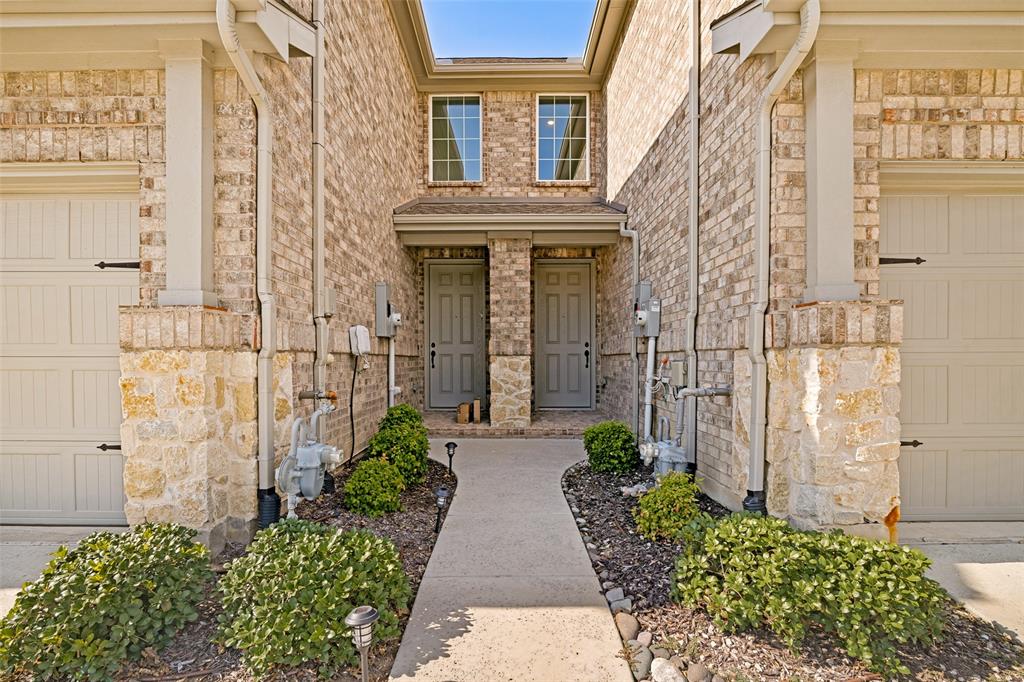 1006 Emil Place Allen, TX 75013 - Photo 3 of 28 Brick exterior with stone accents, featuring two individual entry doors and two garage doors