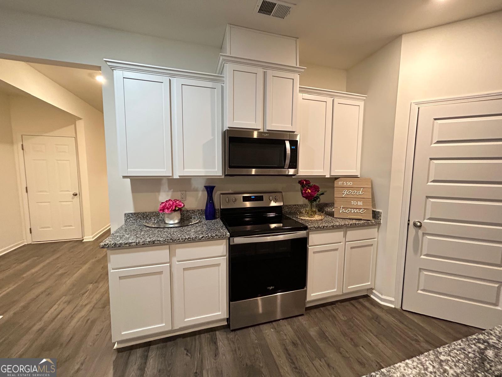 215 Barnyard Way Perry, GA 31069 - Photo 14 of 29 a kitchen with granite countertop a stove and a wooden floor