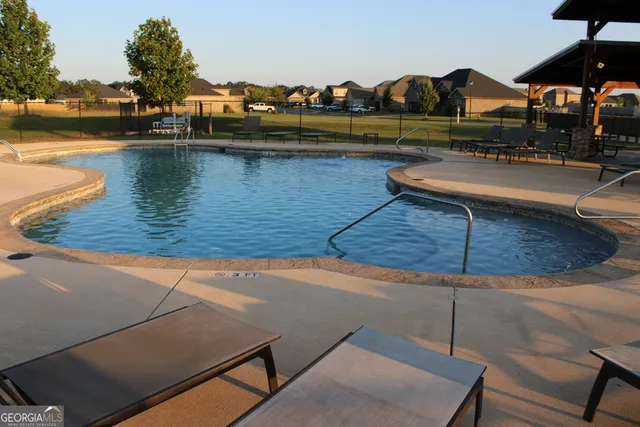 a view of swimming pool with seating space and barbeque oven