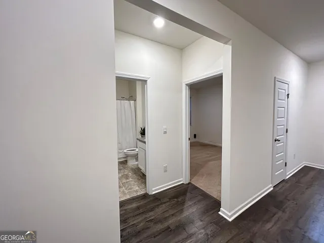 an empty room with wooden floor & windows