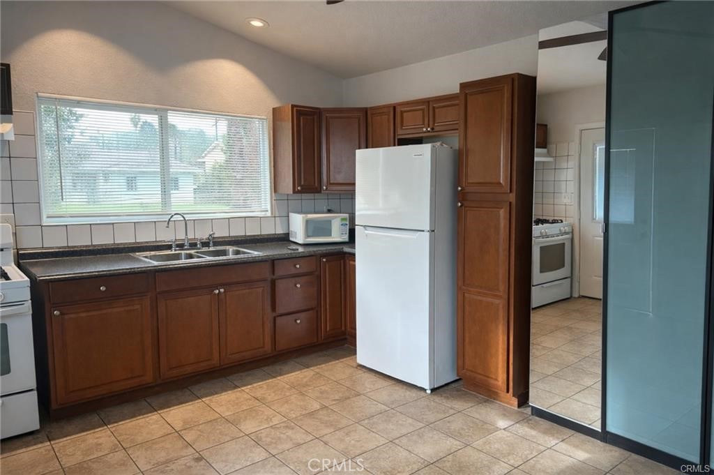 494 Alta Mesa Drive Riverside, CA 92507 - Photo 2 of 9 a kitchen with granite countertop a refrigerator and a sink