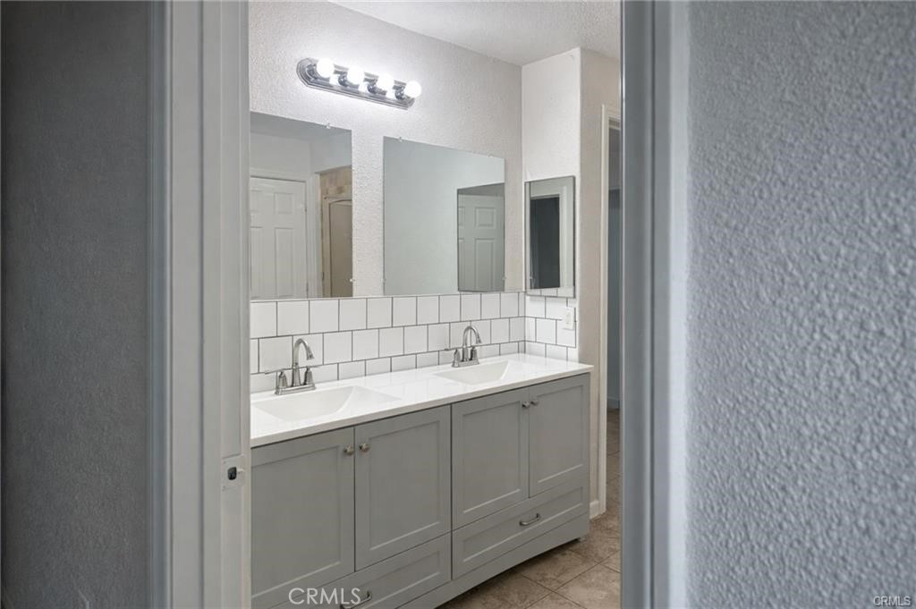 494 Alta Mesa Drive Riverside, CA 92507 - Photo 5 of 9 a bathroom with a double vanity sink and a mirror