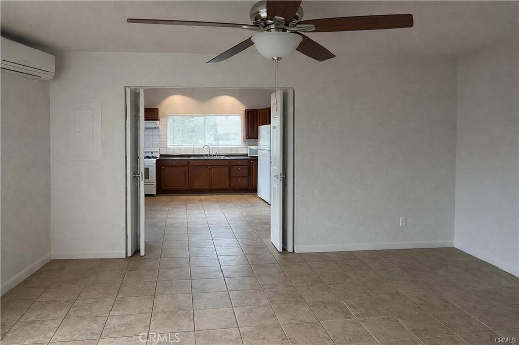 494 Alta Mesa Drive Riverside, CA 92507 - Photo 7 of 9 a view of an empty room with a fireplace and a chandelier fan