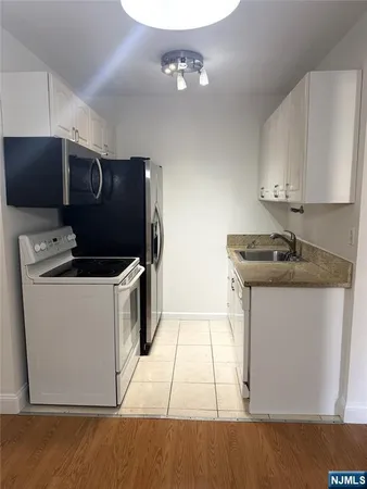 a kitchen with a sink a stove and cabinets