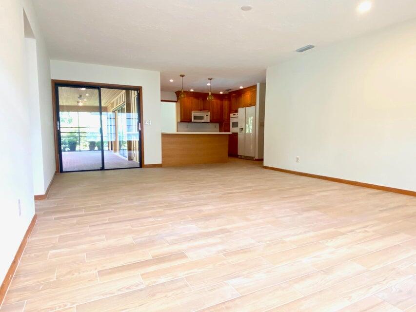 5585 Pennock Point Road Jupiter, FL 33458 - Photo 5 of 19 an empty room with a fireplace and windows