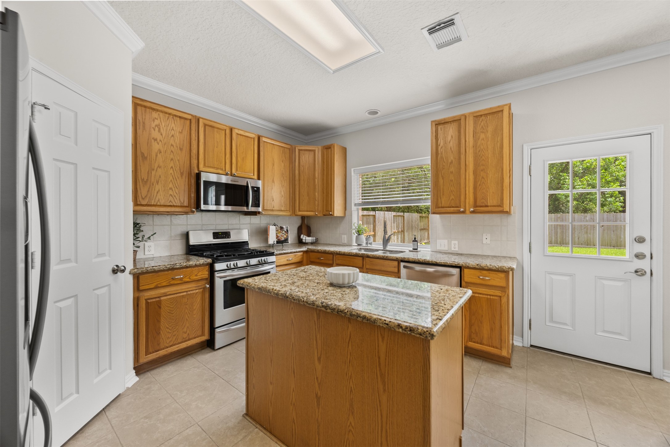 2219 Louetta Brook Lane Spring, TX 77388 - Photo 16 of 34 Bright kitchen featuring granite countertops, stainless steel appliances, and a central island perfect for prep and gathering.