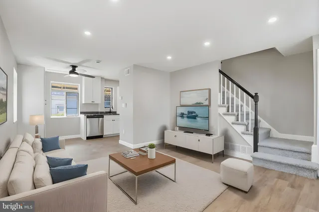 a living room with furniture and a wooden floor