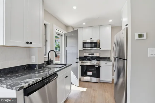 a kitchen with stainless steel appliances granite countertop a stove a refrigerator and a sink