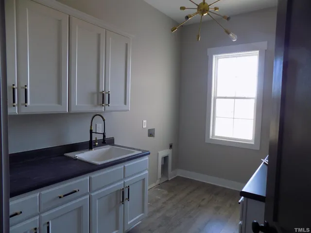 a kitchen with a sink cabinets and wooden floor