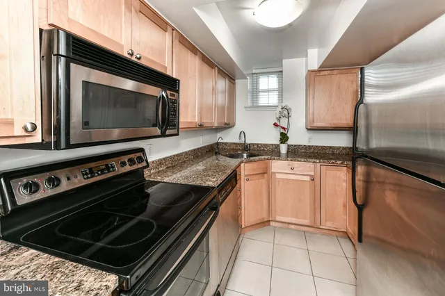 a kitchen with granite countertop a stove microwave and sink