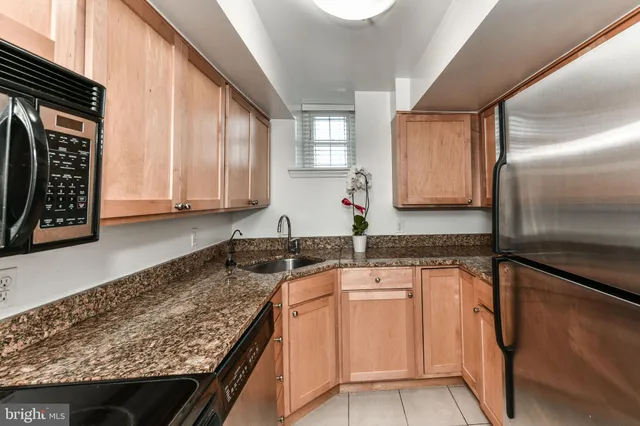 a kitchen with granite countertop a sink a stove and cabinets